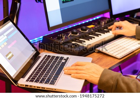 male composer, producer, arranger, song writer, musician hands arranging music on computer in home studio. music production concept Royalty-Free Stock Photo #1948175272