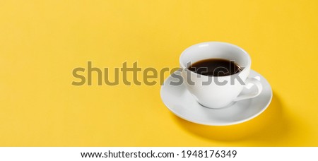 black coffee in white cup on yellow background, banner