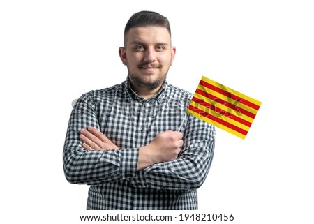 White guy holding a flag of Catalonia smiling confident with crossed arms isolated on a white background.