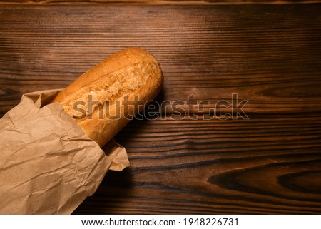 French bread baguette cut on vintage wooden table. Selective focus