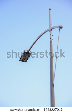 Street light pole with blue sky background.