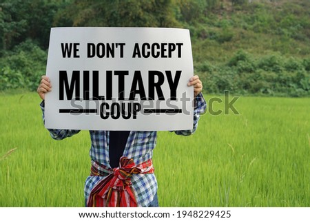 Text" We don't accept military coup" on paper by a man. Concept protest the violence from coup in Myanmar Royalty-Free Stock Photo #1948229425