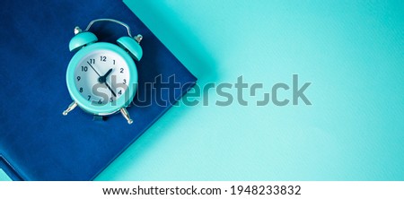 Time management concept: blue watch and notepad