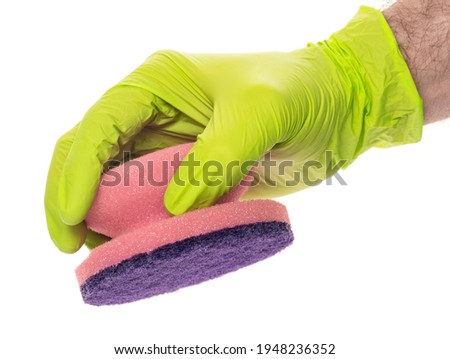 Multi-colored sponges for washing and cleaning in a man's hand. Hand in latex glove isolated on white. A gloved hand holds a selection of sponges