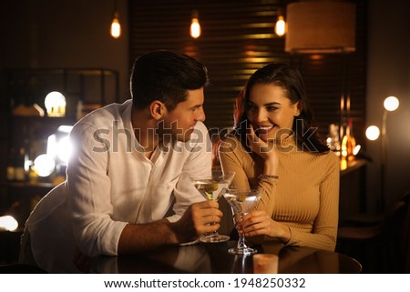 Man and woman flirting with each other in bar Royalty-Free Stock Photo #1948250332