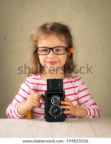 Little girl taking pictures with a vintage film camera.