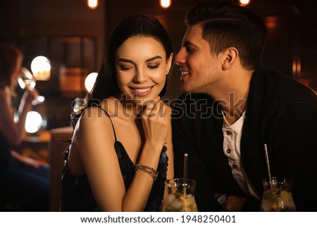 Man and woman flirting with each other in bar Royalty-Free Stock Photo #1948250401