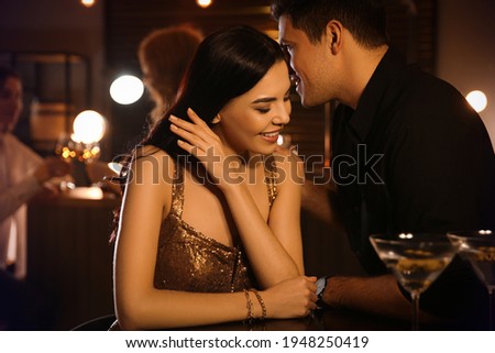 Man and woman flirting with each other in bar Royalty-Free Stock Photo #1948250419