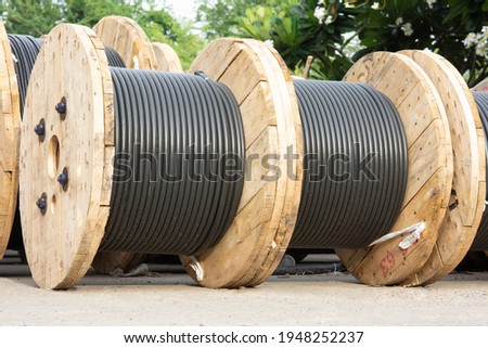Wooden Coils Of Electric Cable Outdoor. High and low voltage cables in the storage Royalty-Free Stock Photo #1948252237