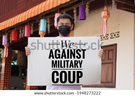 Text " We against military coup" on sign hold by Asian man. Concept protest the violence from the coup in Myanmar. Royalty-Free Stock Photo #1948273222