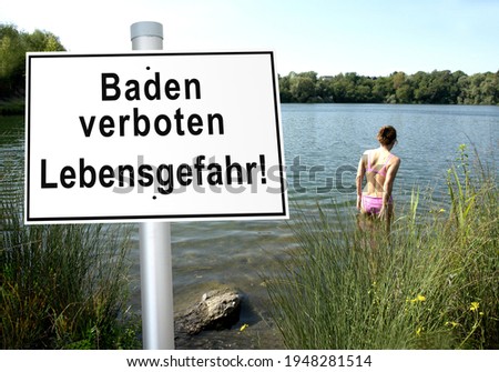            Woman who bathes on the lakeshore, in the foreground sign with the German inscription bathing prohibited, danger to life