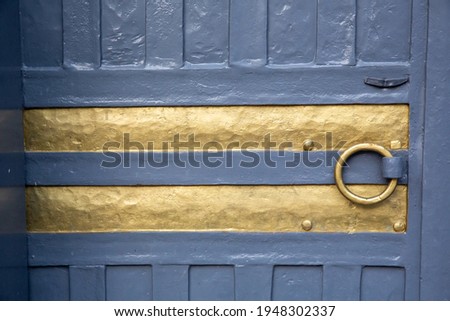 Front view, iron door with gilded stripes and ring-shaped handle background
