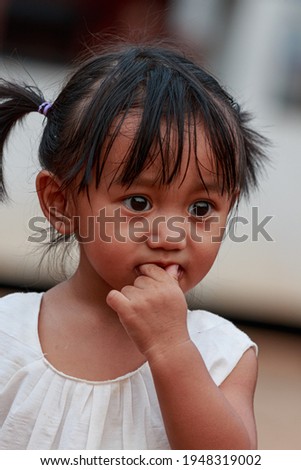 Portrait of asian baby girl, a cute face,Put a hand in the mouth of the fruit