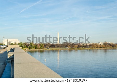 Potomac River Calm Waters and Washington Monument Obelisk in Background. Arlington Bridge Leads to Lincoln Memorial.  Washington DC, USA. Sunny Day with Blue Sky