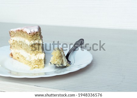 A fork and a slice of vanilla cake. Close-up