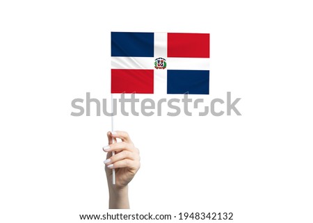 Beautiful female hand holding Dominican Republic flag, isolated on white background.