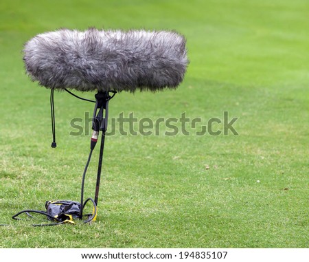 A large microphone boom with windshield for TV or Radio situated at the ground 