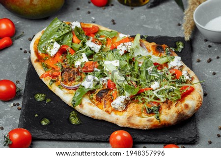 vegetarian pizza with cheese tomatoes and greens.