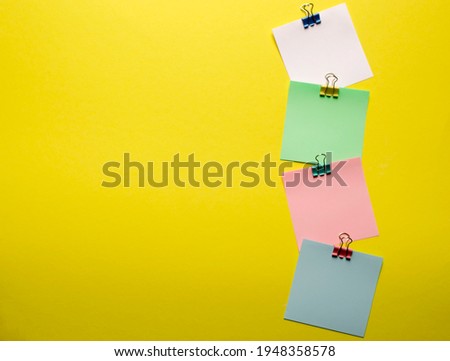 Clips with a paper card template on a yellow background for text or image. Paper layout. Promotions and discounts theme. Copyspace. Spare photo. View from above.Selective focus.