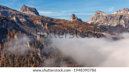 Wonderful sunny morning in Dolomites Alps. Italy. Amazing nature landscape. Aerial View on mountains with forest and morning fog under sunlight. Concept of an ideal resting place. Picture of wild area