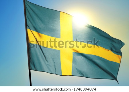 Sweden flag waving on the wind in front of sun