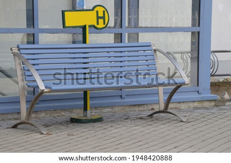 Blue bench in front of building with stop sign