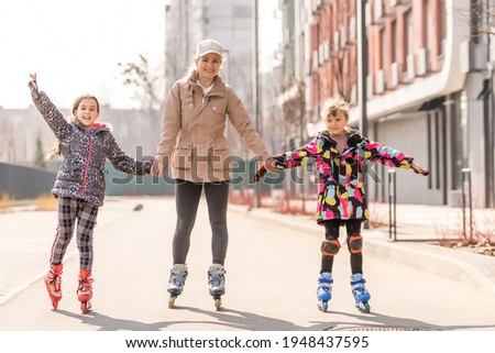 Family rollerskating in park. Active walk. Preschool girl having active walk with her mother