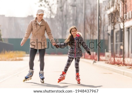 mother teaches daughter to roller skate