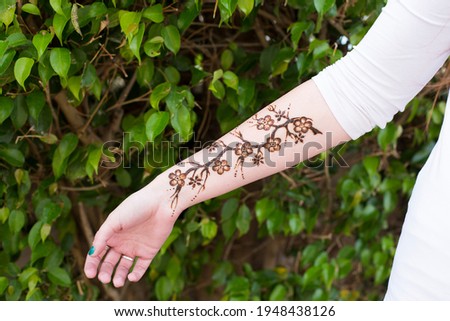 Temporary henna tattoo modern botanical design Sakura branch. Mehendi natural lifestyle.