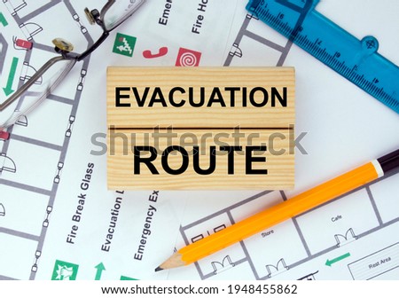 Wooden blocks with text Evacuation Plan Architectural design, sketch, drawing paper, drawings, simple pencil, eyeglasses with protractor on the table