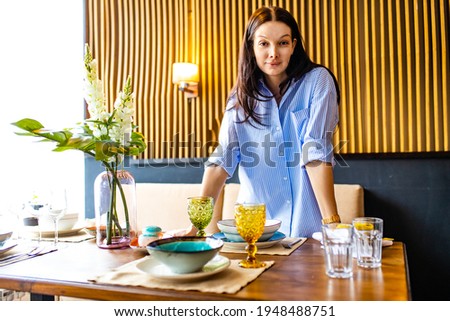 Portrait of one young beautiful caucasian woman washing a dishes and table setting daylight