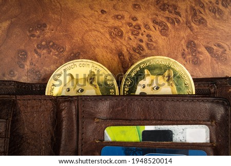 Dogecoins in a wallet on a table Royalty-Free Stock Photo #1948520014