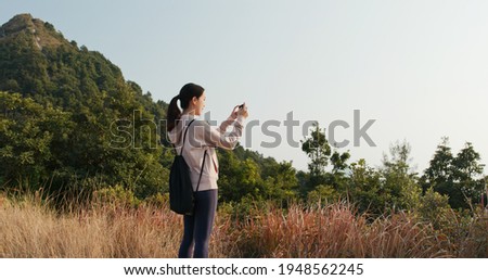 Woman use cellphone to take photo at forest