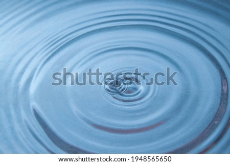 Circles on the surface of blue water close-up. Background image