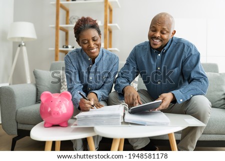 Happy African Couple Doing Retire Finances Plan And Money Budget Royalty-Free Stock Photo #1948581178