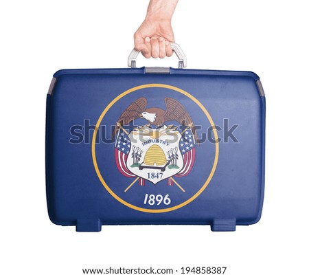 Used plastic suitcase with stains and scratches, printed with flag, Utah