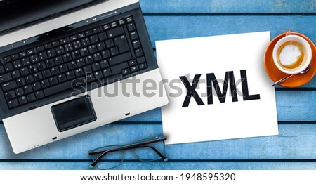 Extensible Markup Language. Word XML on paper and laptop on desk