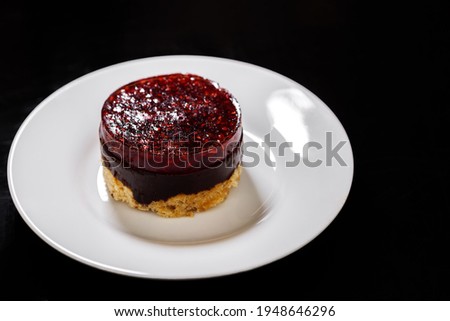 Sponge cake on a plate covered with raspberry jelly on top. Sweet dessert.