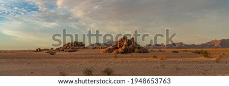 Landscape with rocks of Namib-Naukluft National Park at Sesriem, Sossusvlei, part of the Namib Desert during sunset, panorama Royalty-Free Stock Photo #1948653763