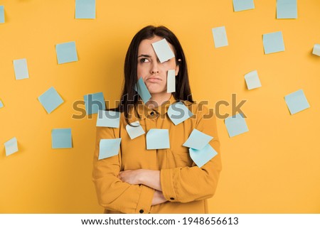 Attractive girl on a yellow background pasted with stickers. Stickers on the face and on the wall, copy space, place for text. Royalty-Free Stock Photo #1948656613