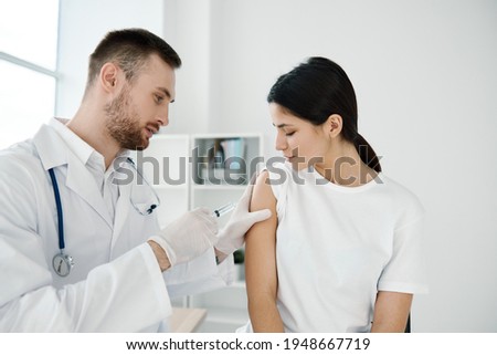 woman in hospital and doctor injecting coronavirus vaccine