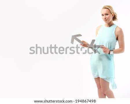 Success in business .Elegant young woman pointing with silver arrows. 