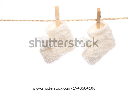Baby clothes on a clothesline on white  background . knitted socks- Image 
