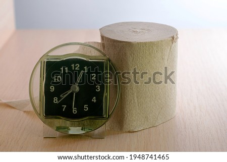 a roll of toilet paper and a clock on the shelf concept daily routine proper nutrition. High quality photo