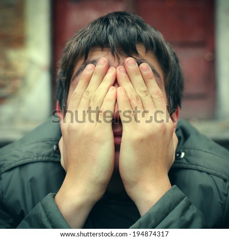 Toned photo of Sad Teenager with hidden Face closeup