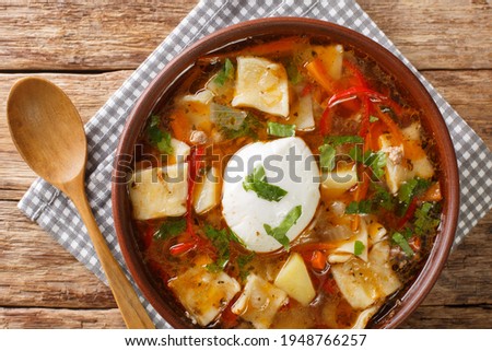 Chilean soup Pantruca or Pancutra with vegetables, minced meat and homemade noodles close-up in a bowl on the table. horizontal top view from above
