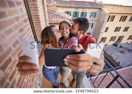 Group of cheerful friends taking selfie on a sunny day