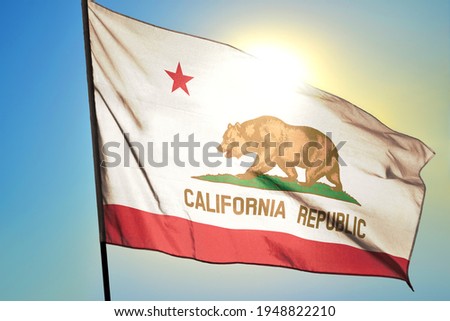 California state of United States flag waving on the wind in front of sun