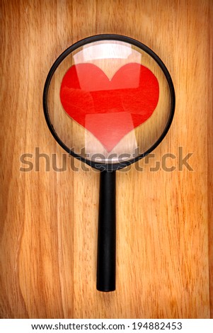 Heart Shape in the Loupe on the Wooden Background