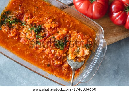 Trout in tomato sauce with vegetables, garnished with parsley